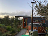 Ember Woodfired Hot Tub in a lush garden setting at a Geelong property, featuring an external wood heater.