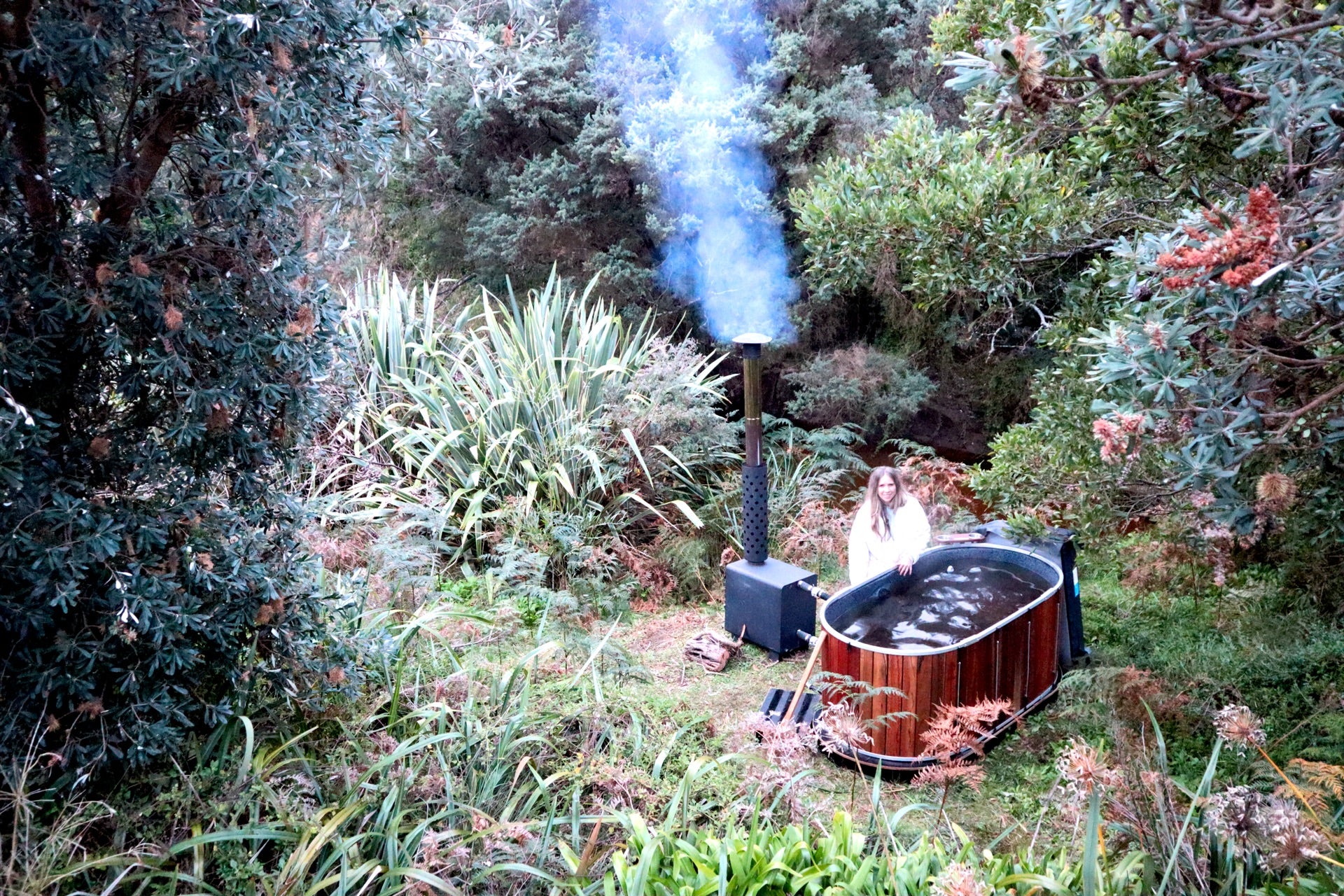 Relaxing in an Ember wood-fired hot tub in a natural outdoor setting