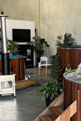 Wooden hot tub in a showroom with plants and furniture
